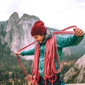 Rock Climbing Guy Coiling a rope in Yosemite National Park
