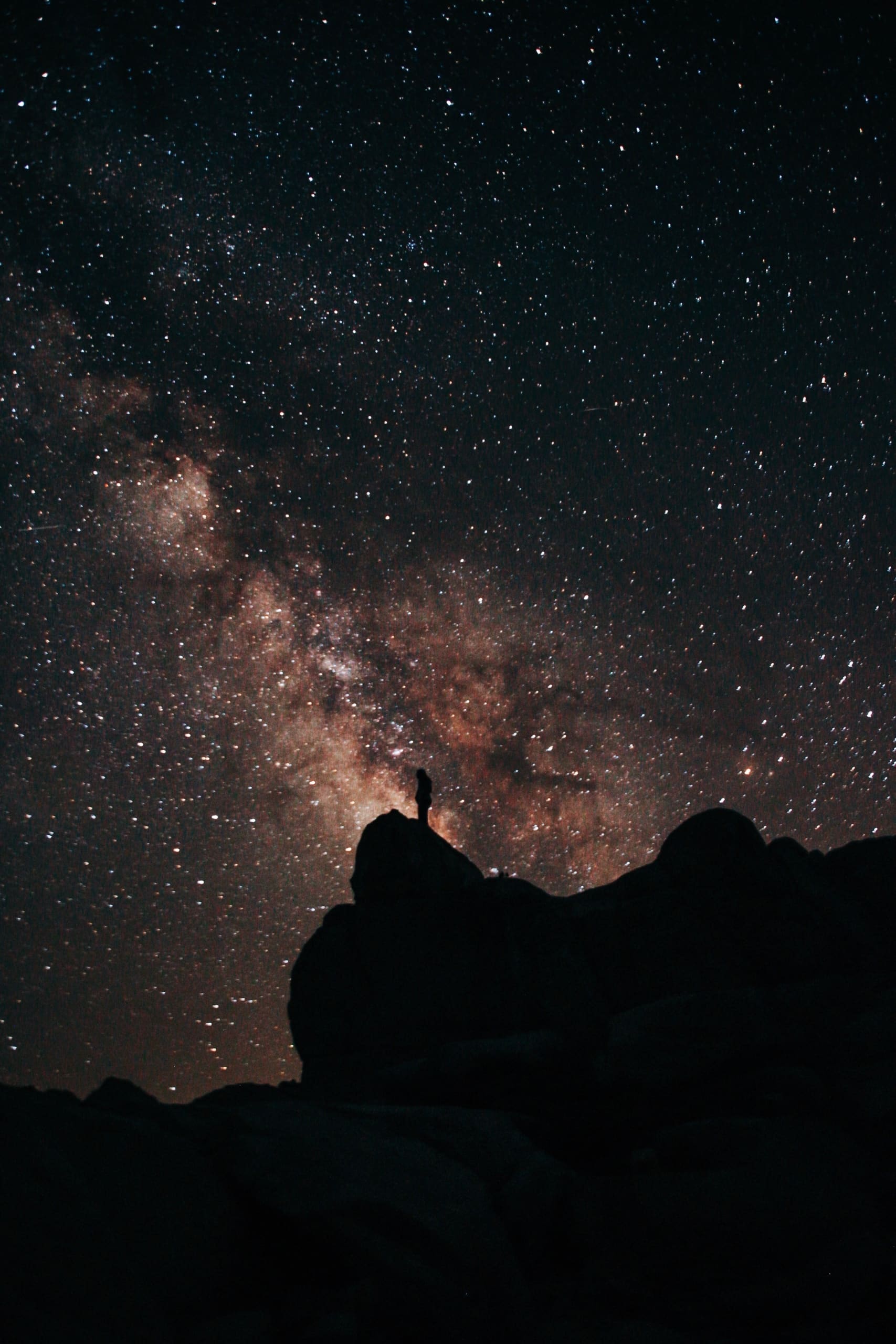 A picture of a person standing under the Milky Way at night milky way galaxy star shot wilderness